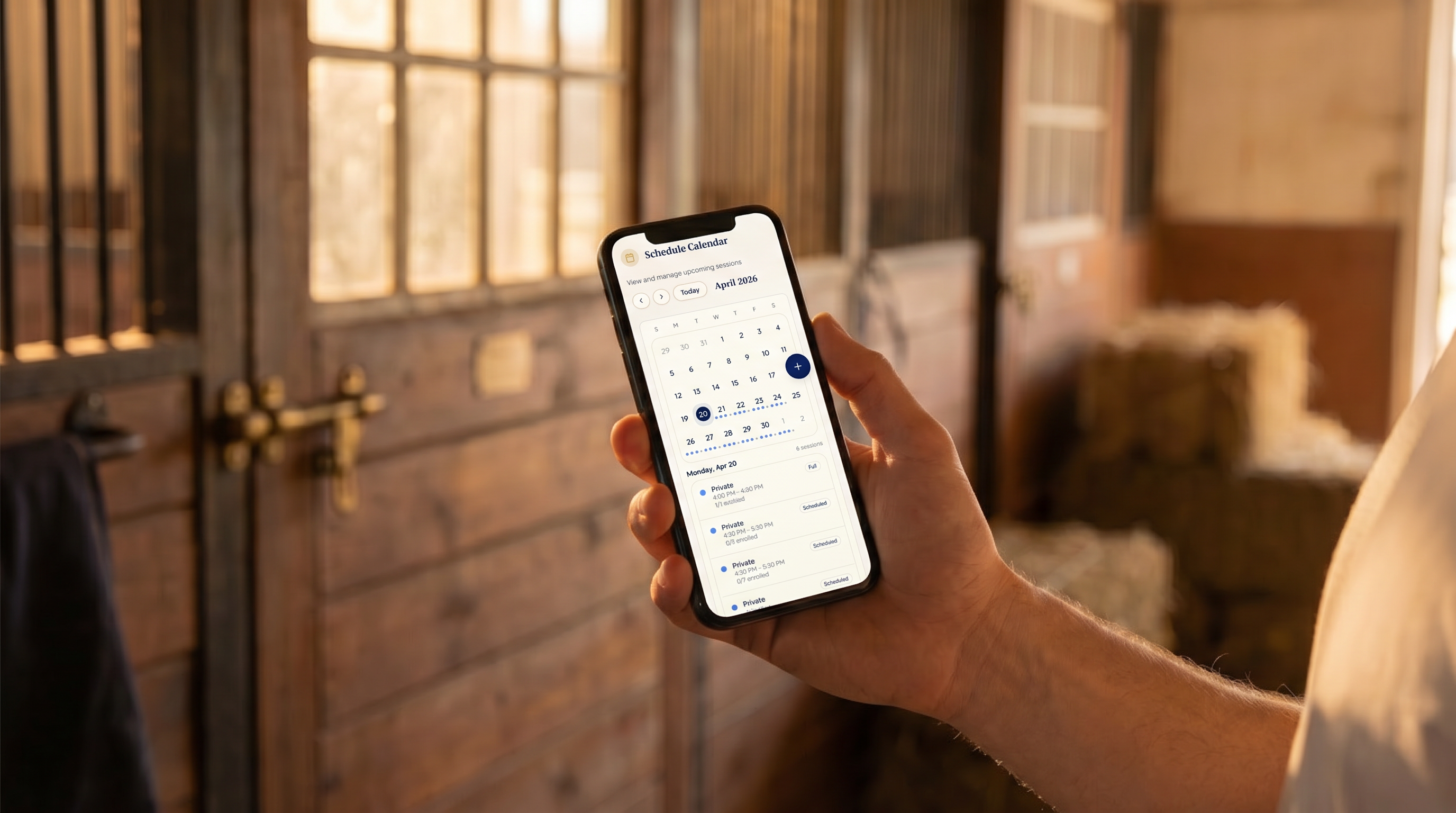 SaddleSync mobile app shown on a phone held in a barn aisle